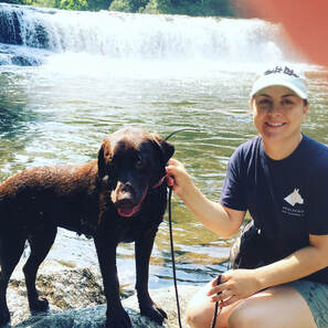 Trainer Katie Weibel sits with Labrador at Hooker Falls NC